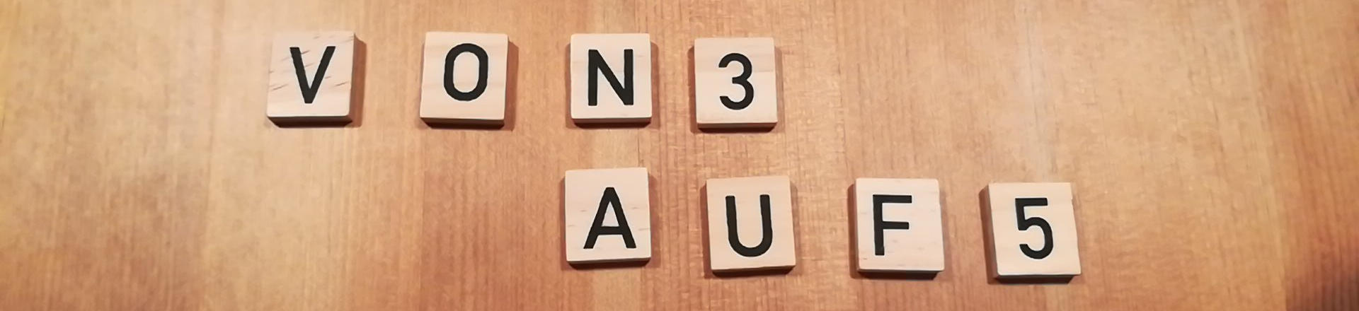 kleine quadratische Holzplättchen mit aufgedruckten schwarzen Buchstaben, die zusammen des Text "von 3 auf 5" ergeben